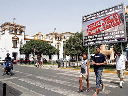 Vecinos de Fuengirola, junto a uno de los carteles-protesta colocados por el Ayuntamiento.