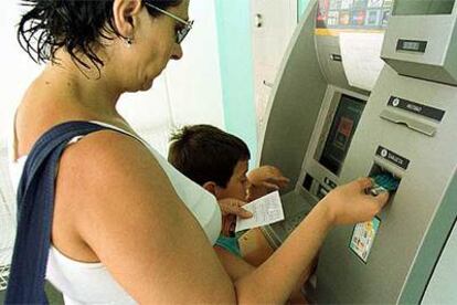 Una mujer utiliza  un cajero automático en  Alicante.