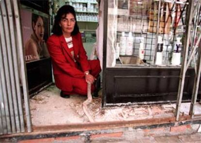 Jazmina Izquierdo, en la puerta de su tienda, coge una raíz.