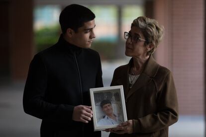 Ana María Arellano y su hijo Pablo Herreruela posan junto a una fotografia de Jose María Herreruela, su marido y padre respectivamente, en su domicilio en Madrid, en abril de 2019. José María, con esclerosis múltiple, terminó con su vida a los 53 años ante el grave deterioro al que le estaba conduciendo su enfermedad.