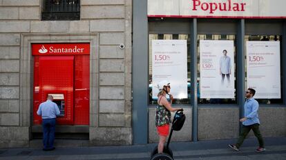 Un hombre saca dinero de un cajero del Santander, la entidad que se ha hecho con el Popular