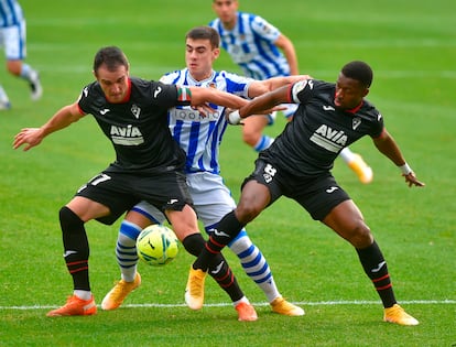 Kike García (izquierda) protege el balón ante Barrenetxea (centro) este domingo en Anoeta.