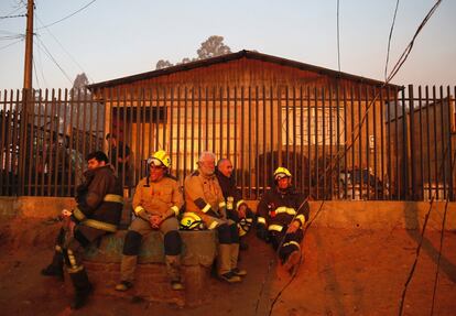 Un grupo de bomberos descansa durante el incendio.