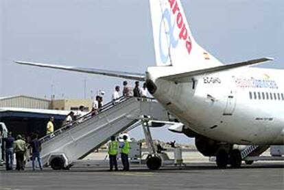 Un grupo de inmigrantes sube por la escalerilla del avión que les trasladó ayer de Fuerteventura a Almería para ser deportados a su país.