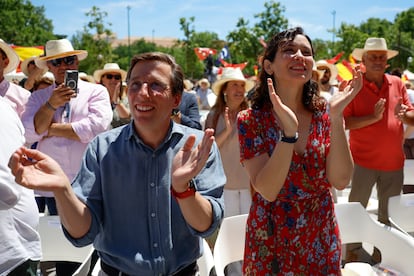 La presidenta de la Comunidad de Madrid, Isabel Díaz Ayuso (d), y el alcalde de Madrid, José Luis Martínez-Almeida (i), el domingo durante un mitin-fiesta del PP madrileño en el Parque de Berlín para hacer balance de su primer año de gobierno, tras las elecciones autonómicas y municipales de mayo de 2023.