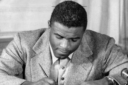 Jackie Robinson, firmando en 1947 su contrato con los Dodgers.