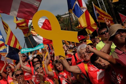 Manifestantes seguram laços amarelos (símbolos separatistas) e bandeiras independentistas da Catalunha durante a manifestação da Diada, o Dia Nacional da região.