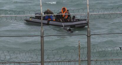 Moroccan soldiers help an immigrant in waters close to Ceuta.