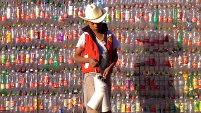 A boy outside a wall made from plastic bottles in Tetela, Mexico.