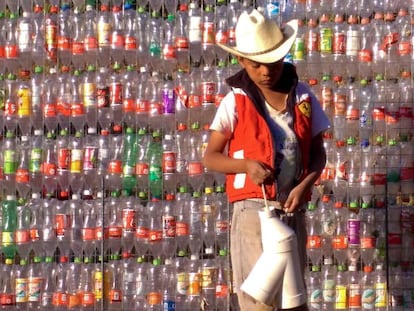 A boy outside a wall made from plastic bottles in Tetela, Mexico.