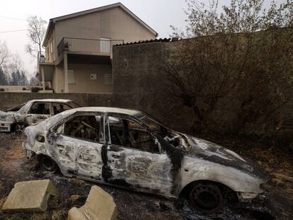 Coches quemados cerca de una vivienda en Penacova, en el norte de Portugal, este lunes.