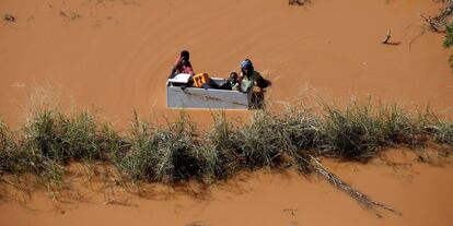 Un grupo de personas flotan sobre una nevera tras las inundaciones provocadas por el paso del ciclón Idai, en Búzi (Mozambique).