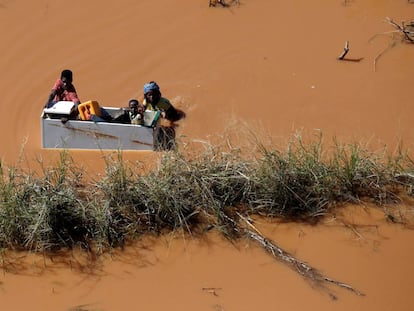 Un grupo de personas flotan sobre una nevera tras las inundaciones provocadas por el paso del ciclón Idai, en Búzi (Mozambique).