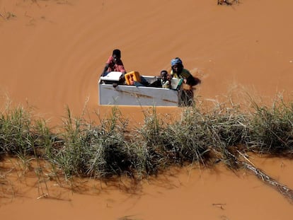 Un grupo de personas flotan sobre una nevera tras las inundaciones provocadas por el paso del ciclón Idai, en Búzi (Mozambique).