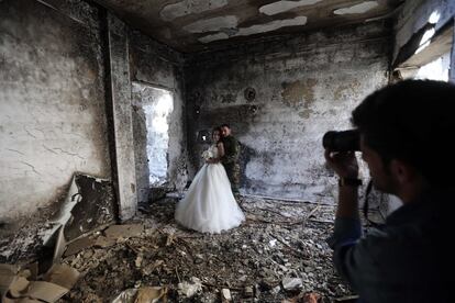 Una pareja de recién casados ​​sirios se hace las fotos de boda en un edificio muy dañado en Homs.