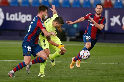 Postigo y Miramón intentan robar el balón a Luis Suárez.