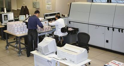 Dos operarios alimentan la máquina.