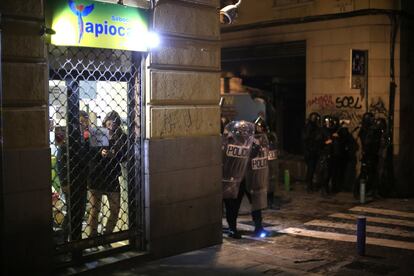 Varias personas se protegen en un local durante los enfrentamientos. 