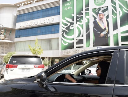 Una mujer saudí conduce en junio de 2018, de fondo un afiche del rey Salmán.