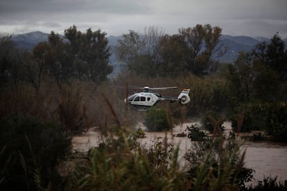 Un helicóptero de la Guardi Civil sobrevuela un campo inundado cerca del barrio de Doñana en Cartama, Málaga, el 4 de diciembre de 2016.