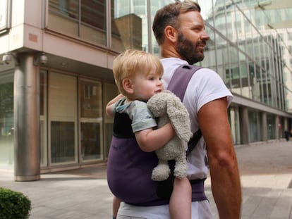 Un padre lleva a su hijo en una mochila portabeb&eacute;s.