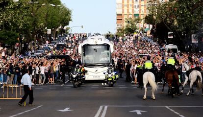 Aficionados del Real Madrid reciben el autobús que traslada a los jugadores al estadio Santiago Bernabeú.