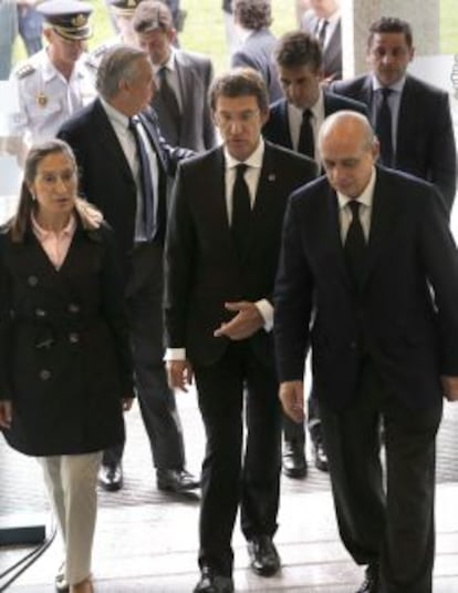 El ministro del Interior, Jorge Fern&aacute;ndez D&iacute;az,(derecha), acompa&ntilde;ado por la ministra de Fomento, Ana Pastor, (izquierda), y el presidente de la Xunta de Galicia, Alberto N&uacute;&ntilde;ez Feij&oacute;o,(centro), entre otros, a su llegada a la Comisaria de Santiago.