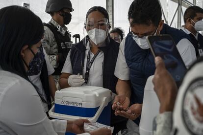 La vacuna ha sido fuertemente custodiada por las fuerzas de seguridad del país por miedo a robos. En la imagen, personal sanitario realiza un recuento de las dosis aplicadas mientras un miembro de la Guardia Nacional graba la operación.