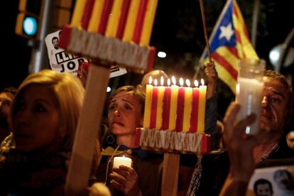 Manifestantes seguram velas com as cores da bandeira de Catalunha.