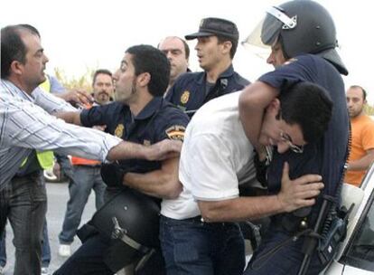 Policías antidisturbios reducen a miembros de un piquete frente a las instalaciones del puerto de Motril que querían evitar el paso de camiones con carburante.