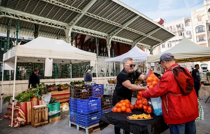 Un hombre compra naranjas en un puesto del nuevo mercado de la huerta del Pla del Remei, este martes.