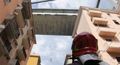 Un bombero observa los edificios evacuados bajo los restos del puente Morandi, en Génova.