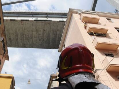 Un bombero observa los edificios evacuados bajo los restos del puente Morandi, en Génova. 