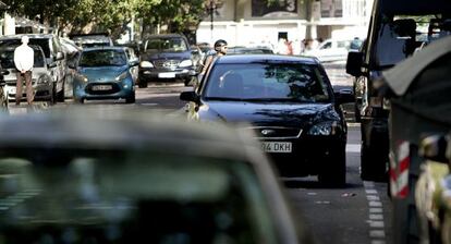 Coches estacionados en doble fila en una calle de Valencia. 