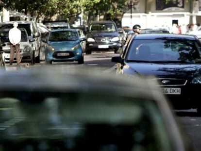 Coches estacionados en doble fila en una calle de Valencia. 