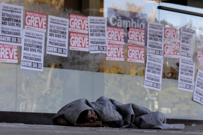 Un hombre sin hogar duerme frente a un banco de Brasilia cerrado por la segunda huelga general en Brasil.