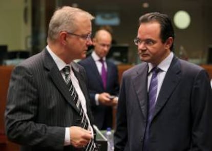 El exministro griego de Finanzas, Yorgos Papakonstantinu (d), conversa con el comisario europeo de Asuntos económicos y monetarios, Olli Rehn (i), antes de la reuinón del Ecofin en Bruselas (Bélgica). EFE/Archivo