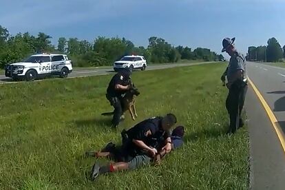 Truck driver Jadarrius Rose, 23 is handcuffed by an Ohio State Highway Patrol (OSHP) officer as a police dog is held back after Rose was attacked by the animal during a traffic stop south of Columbus, Ohio, U.S. July 4, 2023