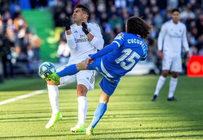 El centrocampista brasileño del Real Madrid, Carlos Casemiro, y el centrocampista del Getafe, Marc Cucurella, luchan por hacerse con el balón en una jugada del encuentro.