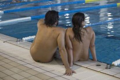 Una parella a la piscina Picornell en horari nudista.