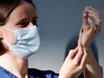 A member of the vaccinating team prepares a dose of the Pfizer-BioNTech Covid-19 vaccine in the Turbine Hall at a temporary Covid-19 vaccine centre at the Tate Modern in central London on July 16, 2021. (Photo by Tolga Akmen / AFP)