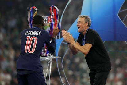  Ousmane Dembele besa el trofeo de la UEFA Champions League, mientras Luis Enrique celebra la victoria de su equipo
