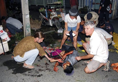 Un grupo de personas socorren a un herido tras una explosión en Hua Hin (Tailandia).