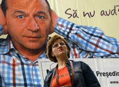 Una mujer pasa por delante de un cartel del presidente rumano, Traian Basescu.
