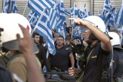 Policías antidisturbios tratan de contener a los partidarios de la extrema derecha que se congregaron frente a la sede de la policía de Atenas para protestar por la detención del lider de su partido.