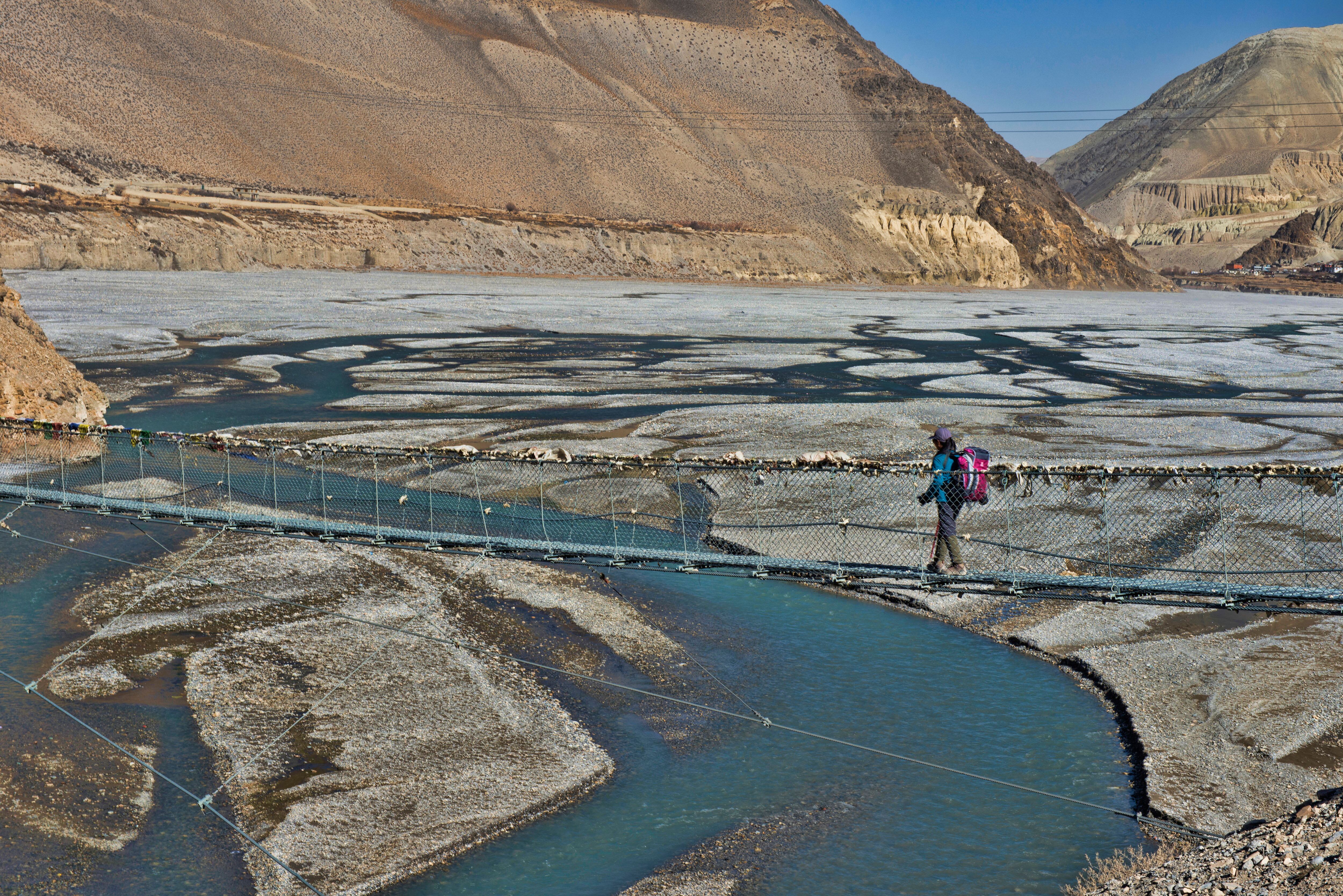 Un senderista traspasa el río Kali Gandaki, en la zona nepalí del Annapurna.