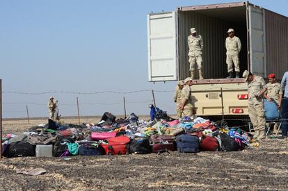 Soldados egipcios recogen pertenencias de los viajeros del avión accidentado en Hassan, península del Sinaí (Egipto).
