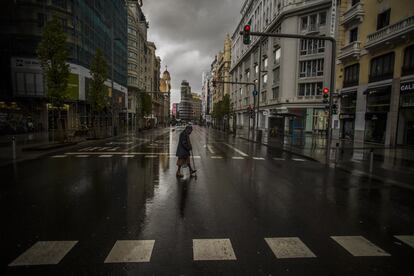 La expansión del virus por España y la declaración del estado de alarma el 14 de marzo dejaron un panorama nunca visto: ciudades casi sin gente ni actividad. En la imagen, una mujer cruza un paso de peatones en la Gran Vía de Madrid, el pasado 23 de marzo.