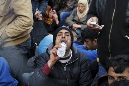 Un migrante bebe agua mientras espera cerca de Idomeni (Grecia), en la frontera con Macedonia.