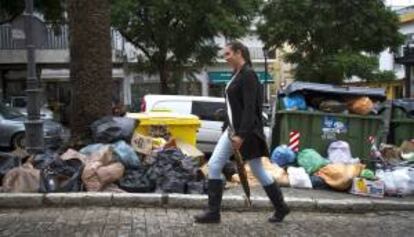 Una mujer pasa cerca de varios contenedores en la localidad gaditana de Jerez de la Frontera, donde se sigue acumulando basuras como consecuencia de la huelga iniciada por los trabajadores de Urbaser, el pasado viernes 2 de noviembre.